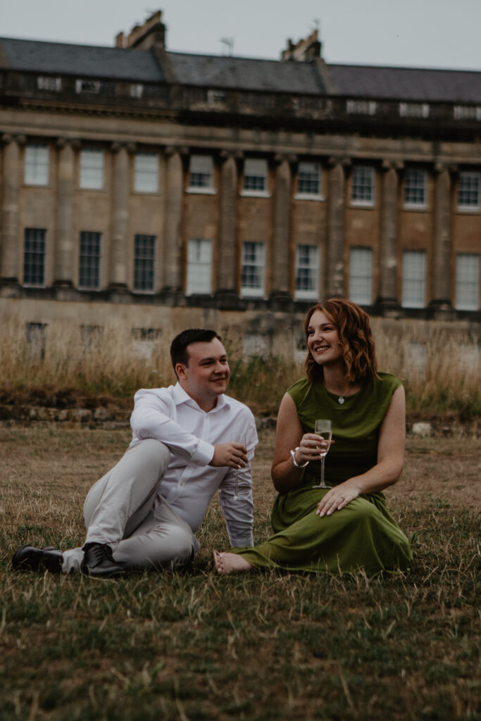 a couple sharing champagne after a proposal photoshoot in bath 