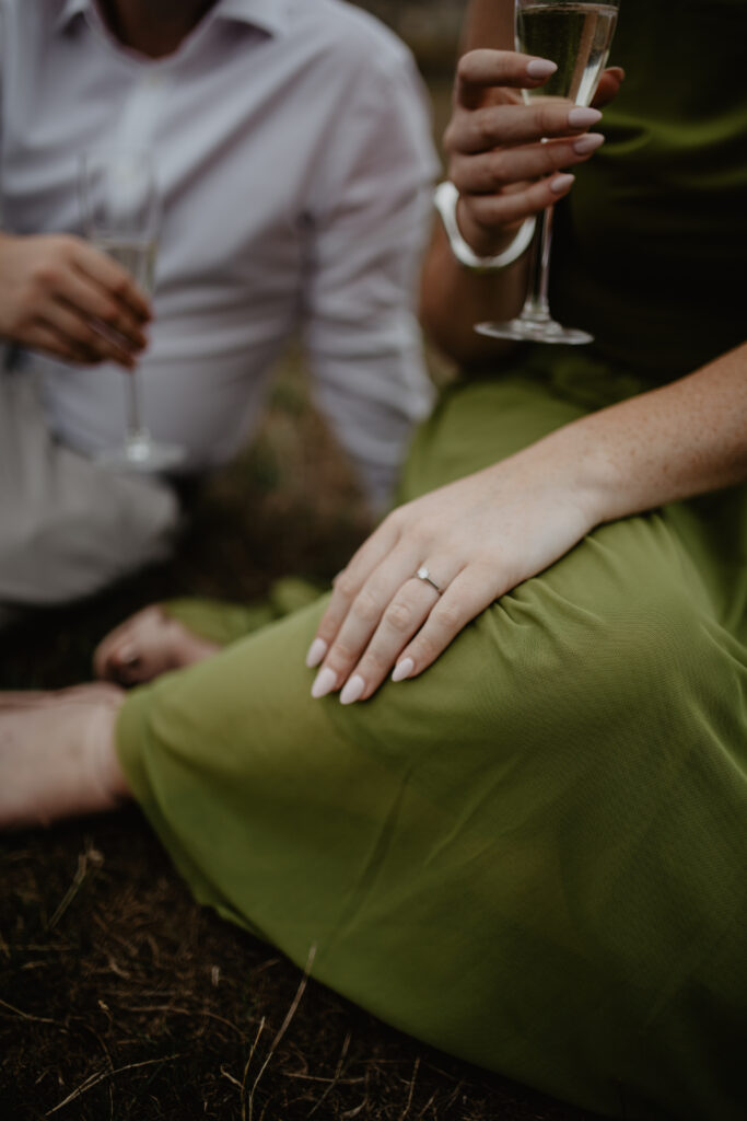 a couple sharing champagne after a proposal in bath during an engagement photoshoot